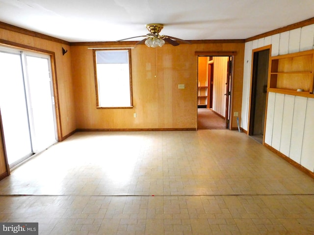 unfurnished room featuring wood walls and ceiling fan