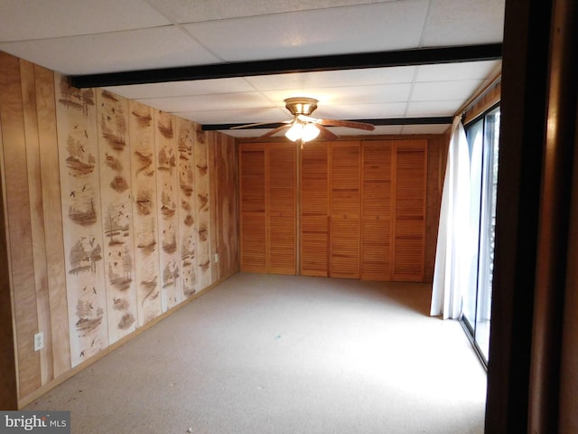 unfurnished room featuring a wealth of natural light, ceiling fan, and a paneled ceiling