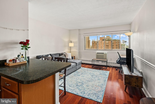 living room featuring a baseboard heating unit, a textured ceiling, and dark hardwood / wood-style floors