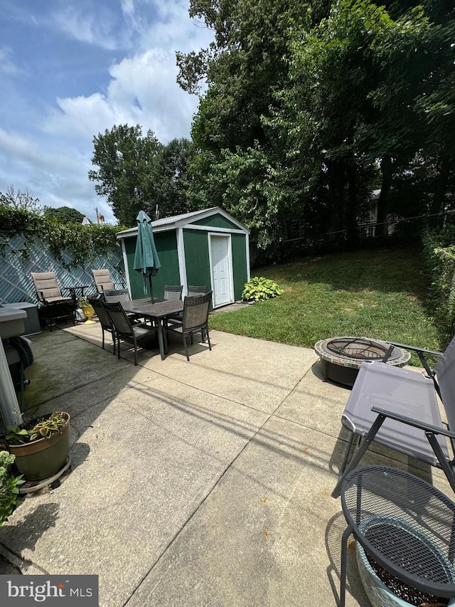 view of patio with a storage unit and an outdoor fire pit