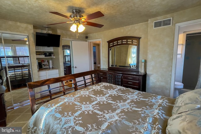 bedroom with ensuite bath, ceiling fan, and a closet