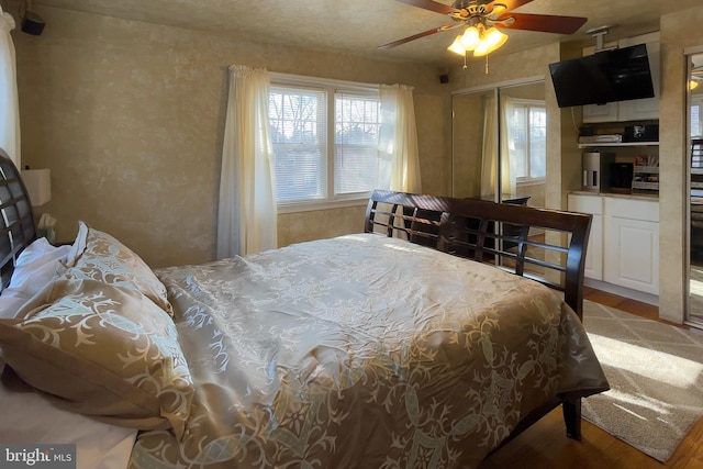 bedroom featuring hardwood / wood-style floors, ceiling fan, and a closet