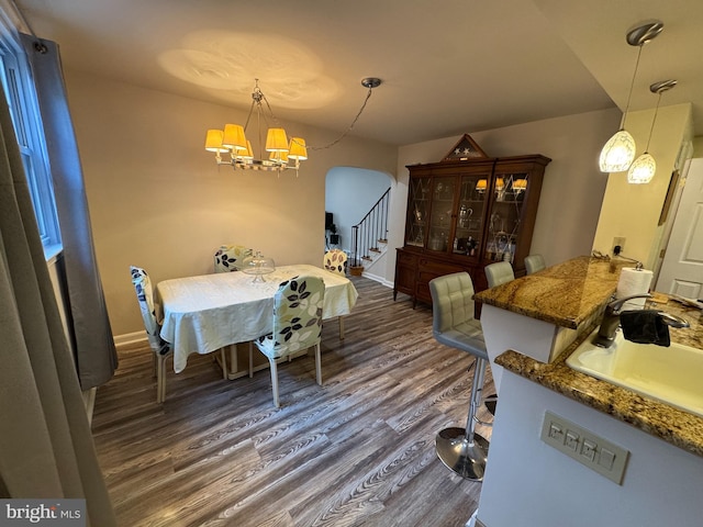 dining area with a notable chandelier, dark hardwood / wood-style flooring, and sink