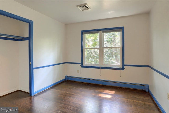 empty room with a baseboard radiator and dark wood-type flooring