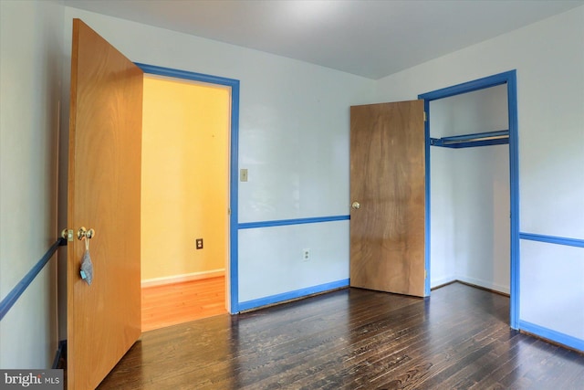 unfurnished bedroom with a closet and hardwood / wood-style floors