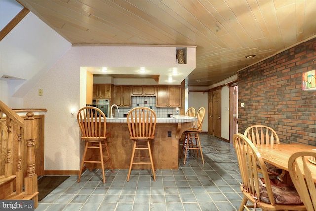 tiled dining room featuring brick wall