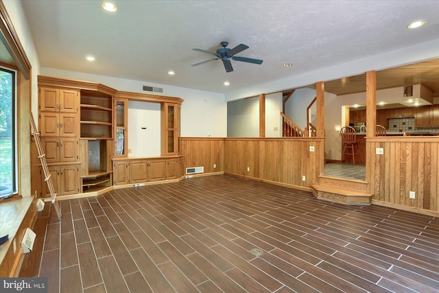 unfurnished living room with dark hardwood / wood-style flooring and ceiling fan