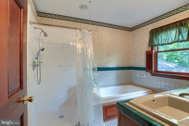 bathroom featuring vanity, tile walls, and separate shower and tub