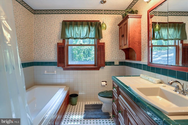 bathroom with vanity, tile patterned floors, tile walls, a bathing tub, and toilet