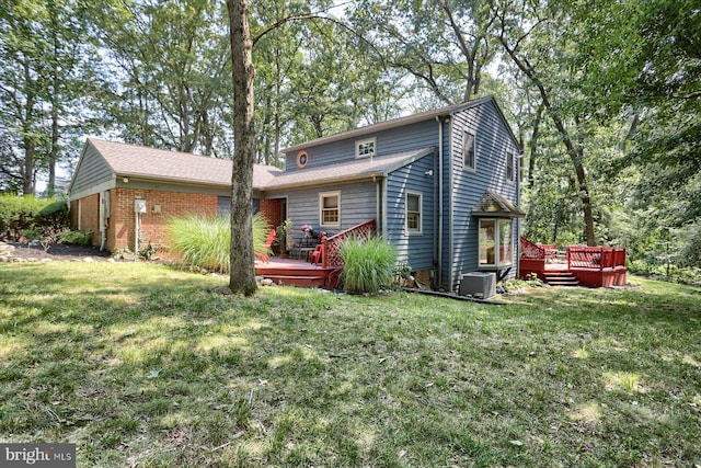 rear view of house featuring a yard and a deck