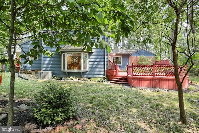 rear view of house featuring central AC, a deck, and a lawn