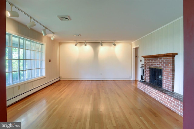 unfurnished living room featuring a baseboard radiator, light hardwood / wood-style flooring, a fireplace, and track lighting