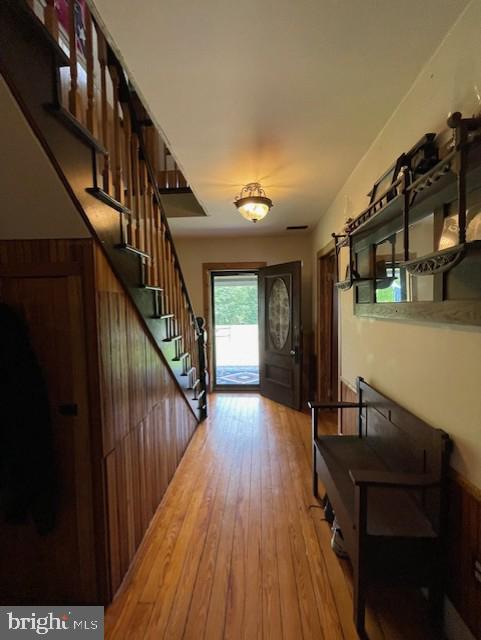 entrance foyer with light hardwood / wood-style flooring and wooden walls