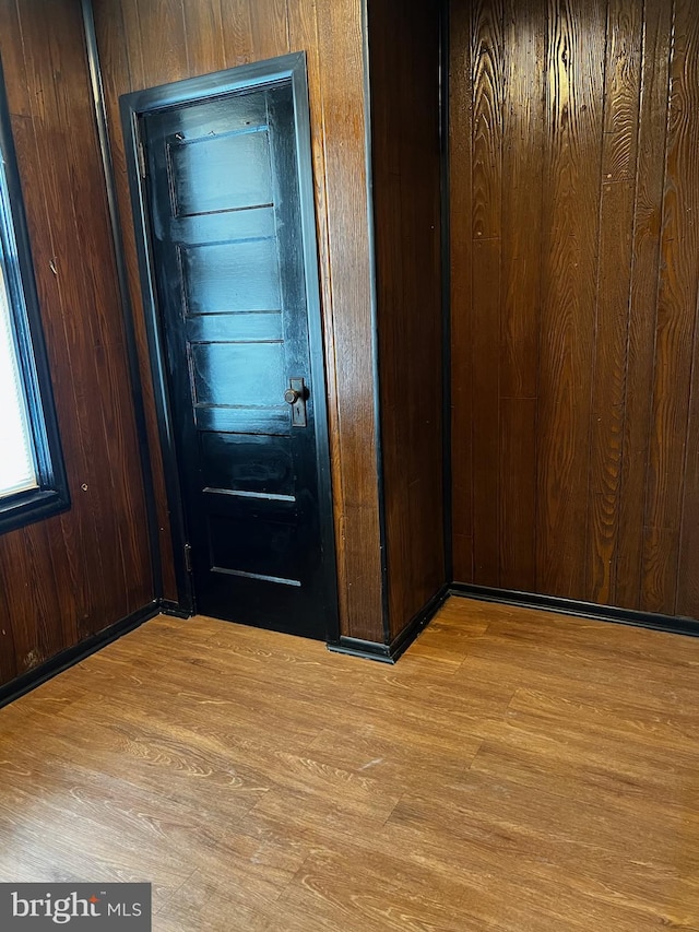 doorway featuring wood walls and light hardwood / wood-style flooring