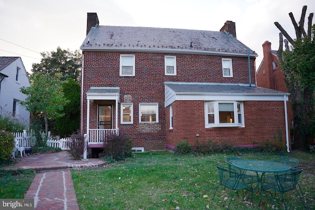 back of property featuring a lawn and a patio