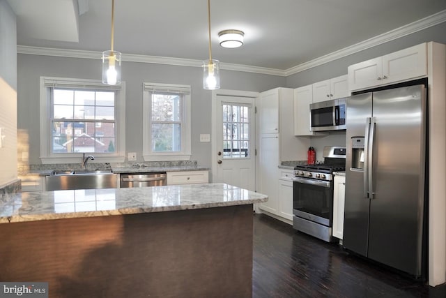 kitchen with appliances with stainless steel finishes, white cabinets, sink, hanging light fixtures, and light stone counters