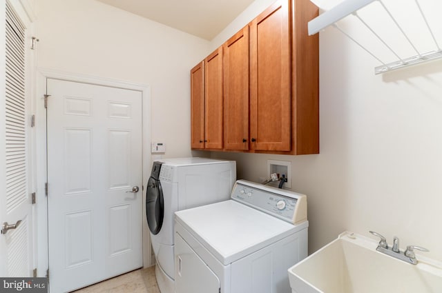 clothes washing area with cabinets, sink, and independent washer and dryer