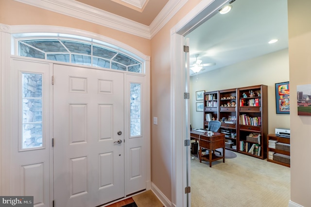 carpeted entryway featuring ceiling fan and crown molding