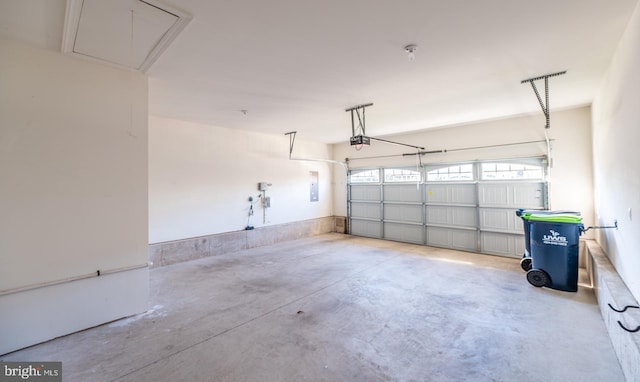 garage with a garage door opener and electric panel