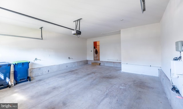 garage featuring independent washer and dryer and a garage door opener