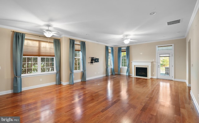 unfurnished living room with hardwood / wood-style flooring, ornamental molding, and ceiling fan