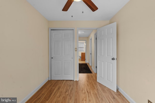 unfurnished bedroom featuring ceiling fan, light hardwood / wood-style floors, and a closet