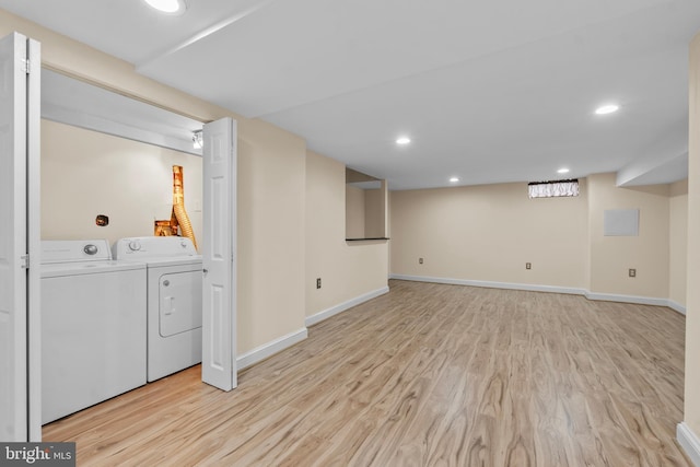 basement featuring light hardwood / wood-style floors and washing machine and clothes dryer