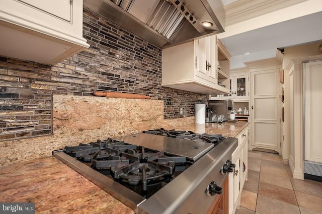 kitchen with decorative backsplash, white cabinets, custom exhaust hood, and light tile patterned floors