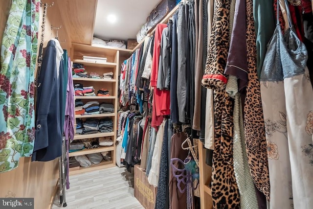 walk in closet with light hardwood / wood-style flooring