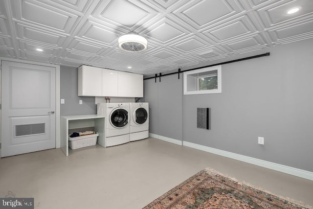 laundry area featuring cabinets, independent washer and dryer, and a barn door