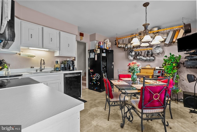 kitchen with white cabinets, sink, decorative light fixtures, and black appliances