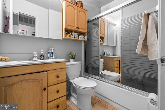 full bathroom featuring tile patterned flooring, vanity, enclosed tub / shower combo, and toilet