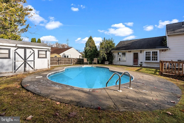 view of pool with a patio and a storage unit