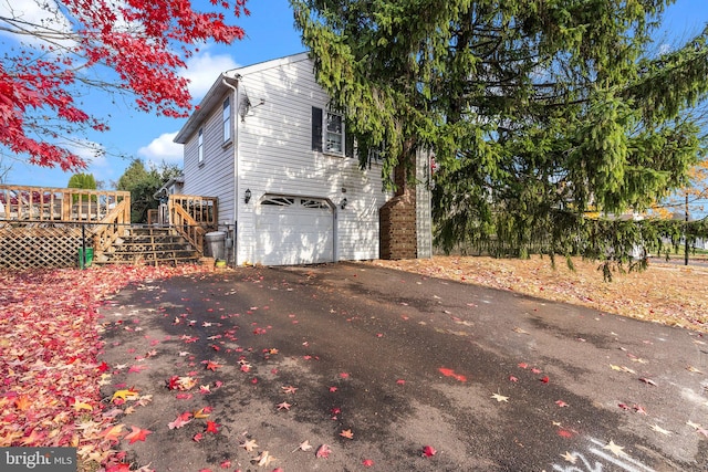 view of property exterior with a garage and a deck