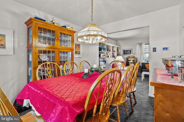 dining area with a notable chandelier and dark carpet