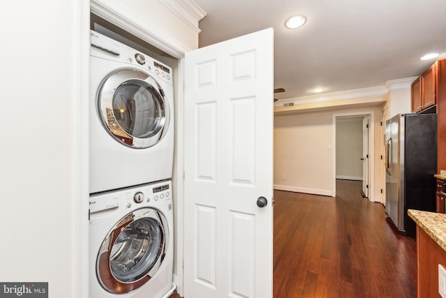 laundry area with stacked washer / dryer, crown molding, and dark wood-type flooring