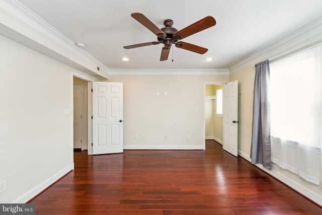 empty room featuring crown molding, dark hardwood / wood-style floors, and a wealth of natural light