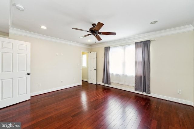 empty room featuring ornamental molding, dark wood-type flooring, and ceiling fan