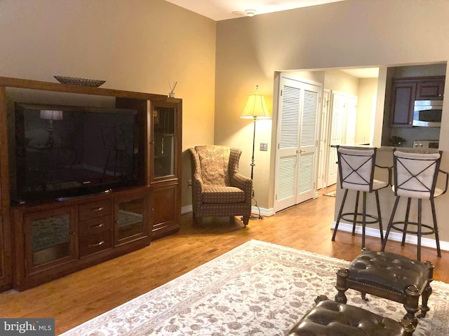 living area with baseboards and light wood-style flooring