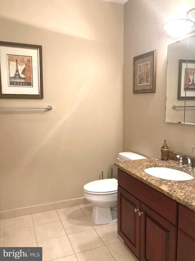 bathroom featuring vanity, toilet, baseboards, and tile patterned flooring