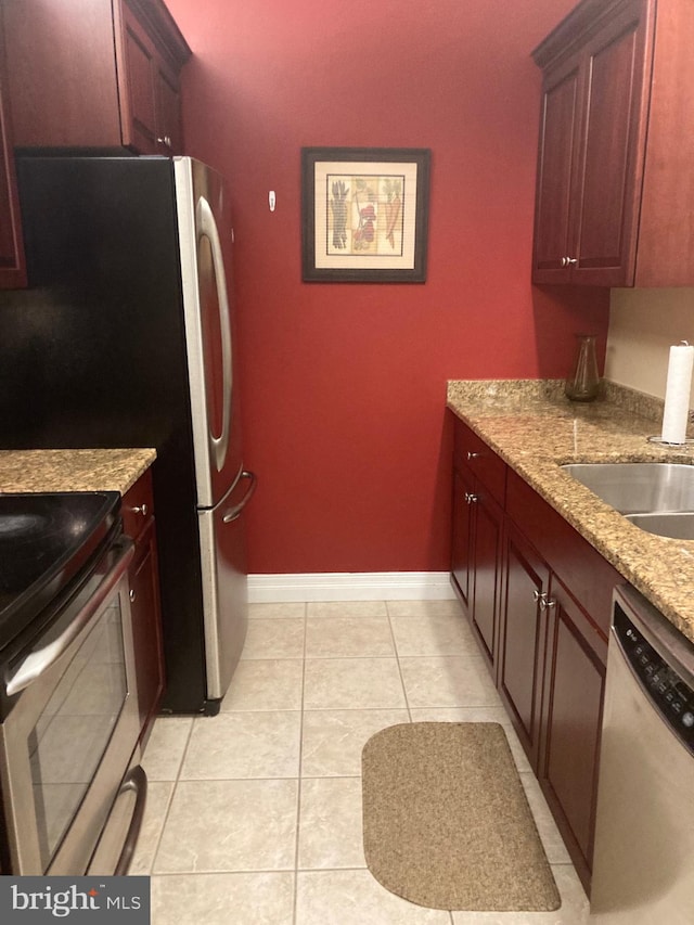 kitchen featuring light tile patterned floors, light stone countertops, sink, and appliances with stainless steel finishes