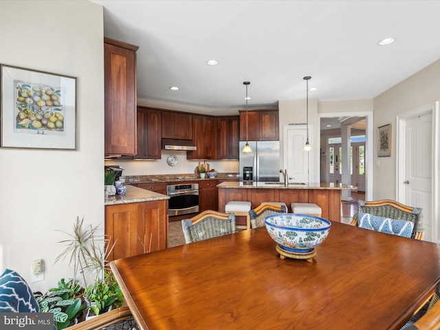 dining area with sink and decorative columns