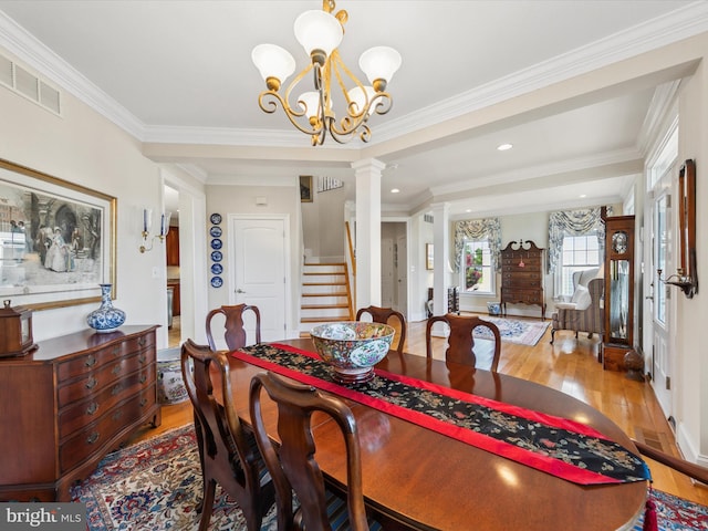 dining room with ornamental molding, light hardwood / wood-style floors, and ornate columns