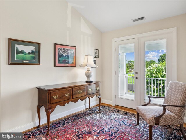 sitting room with vaulted ceiling, hardwood / wood-style floors, and french doors