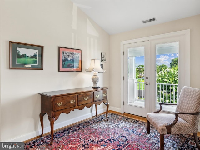 sitting room featuring lofted ceiling, light hardwood / wood-style floors, and french doors