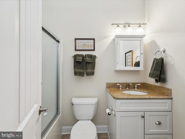 full bathroom featuring vanity, bath / shower combo with glass door, and toilet