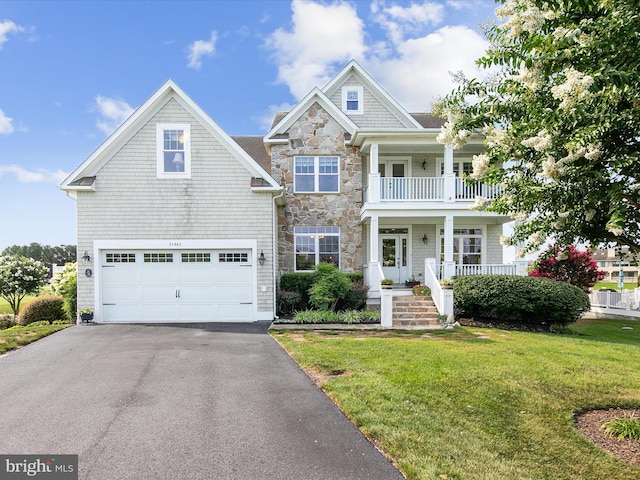 craftsman-style home with a balcony, a garage, and a front lawn