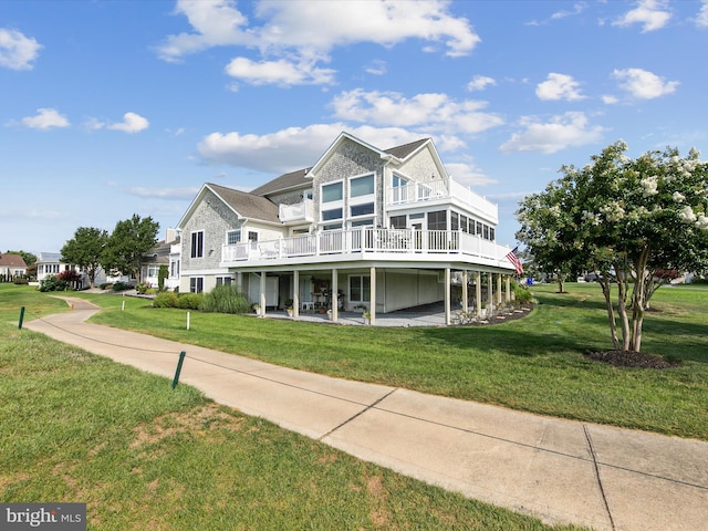 view of front of property with a wooden deck, a patio area, and a front yard