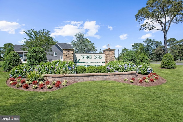 community / neighborhood sign with a yard