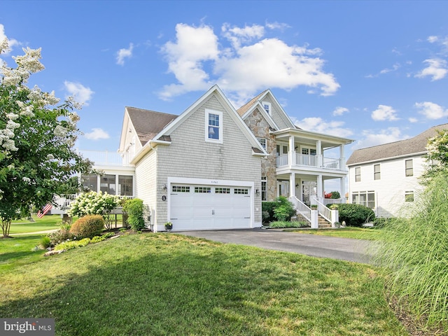 view of front of house featuring a garage, a front yard, and a balcony